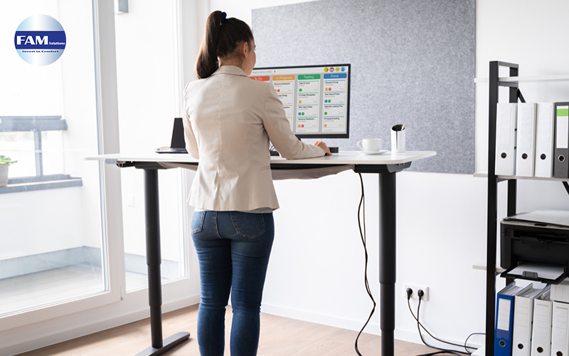 Image of a woman standing using an adjustable table
